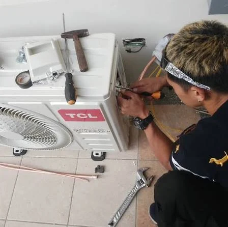 Technician working on connections of an outdoor split-system unit